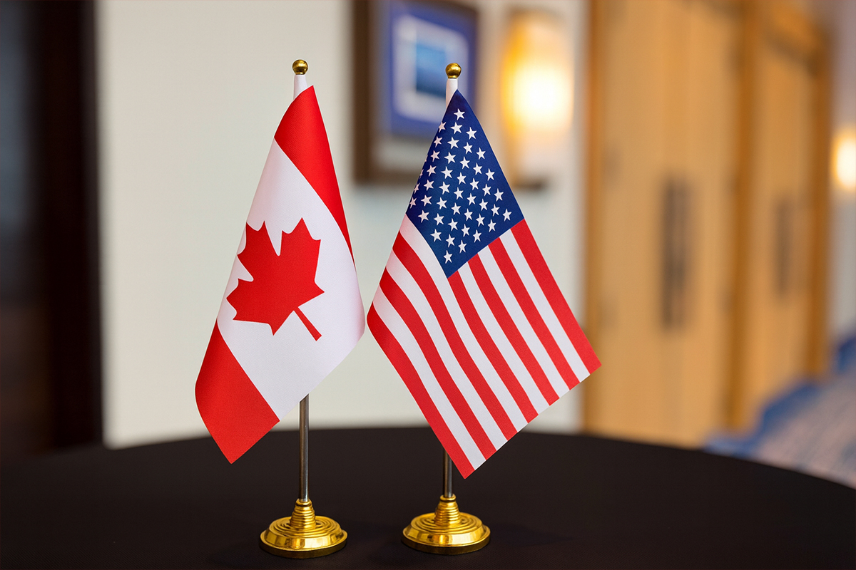 Canada and US flags side by side at a conference, symbolizing cross-border communication, captured for (W)right On Communications.